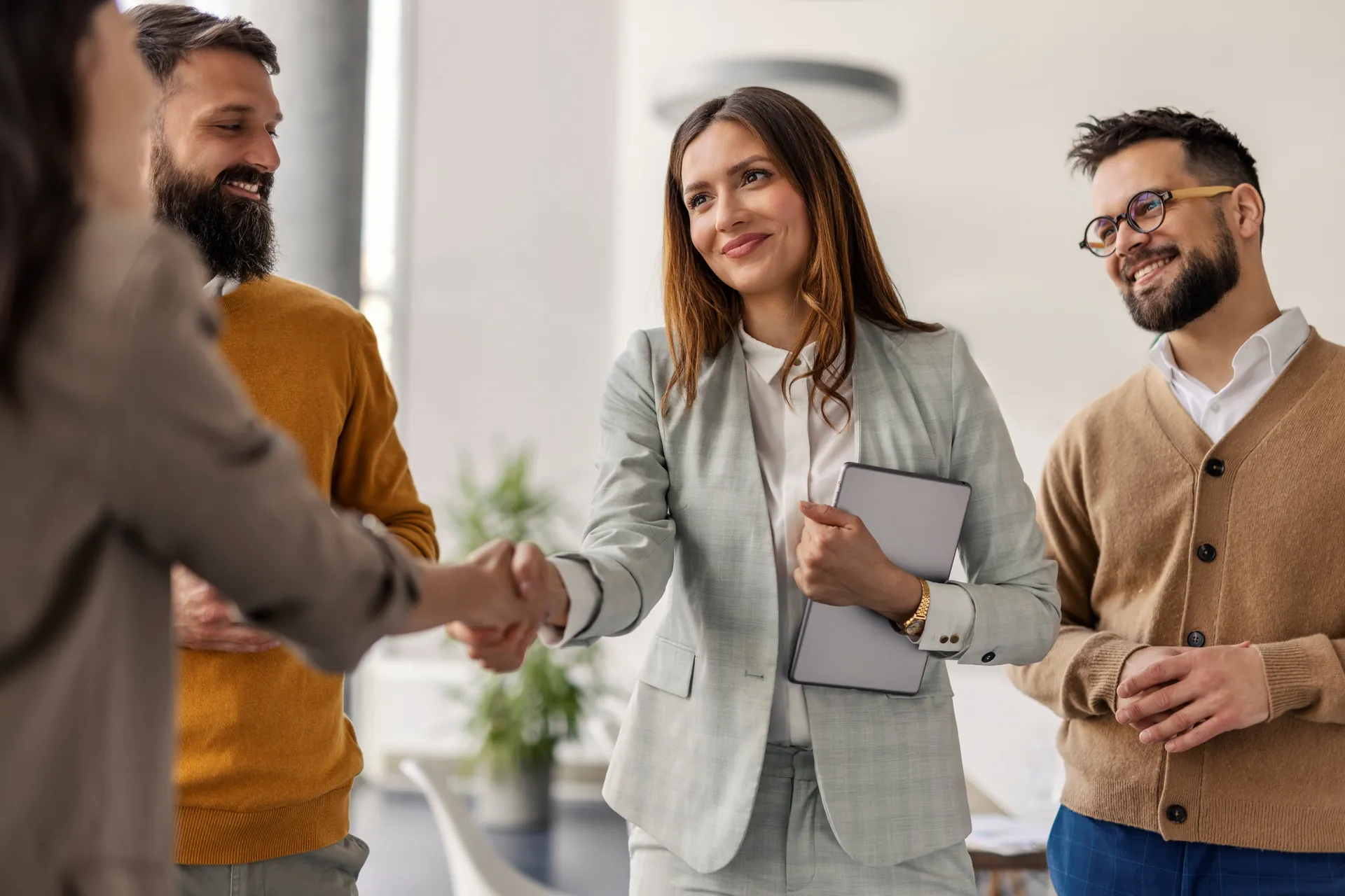 Business partners shaking hands across a meeting table.